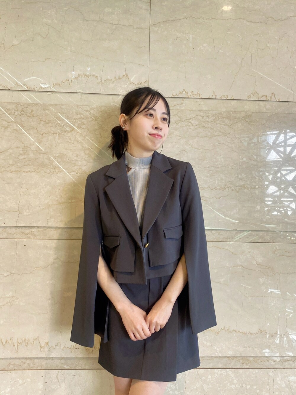 グレー系のテーラードジャケット、グレー系のスカート、グレー系のニット/セーターを着用したレディースの春コーディネートの6枚目の写真