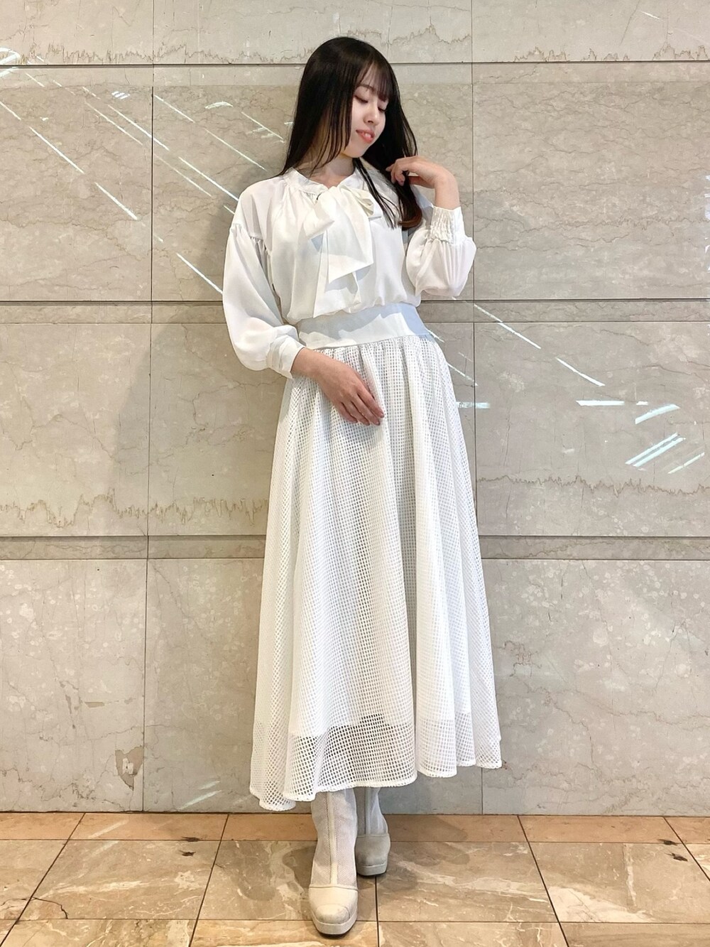 ベージュ系のワンピースを着用したレディースの冬コーディネートの2枚目の写真