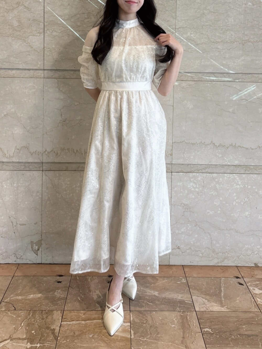 ホワイト系のパンプス、ホワイト系のドレスを着用したレディースの冬コーディネートの2枚目の写真