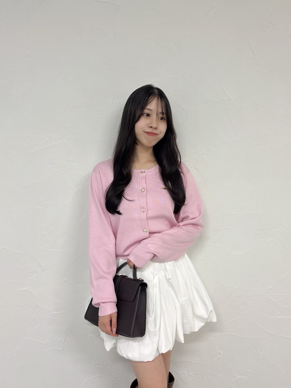 ピンク系のカーディガン/ボレロ、ホワイト系のスカート、ブラウン系のブーツを着用したレディースの秋コーディネートの7枚目の写真