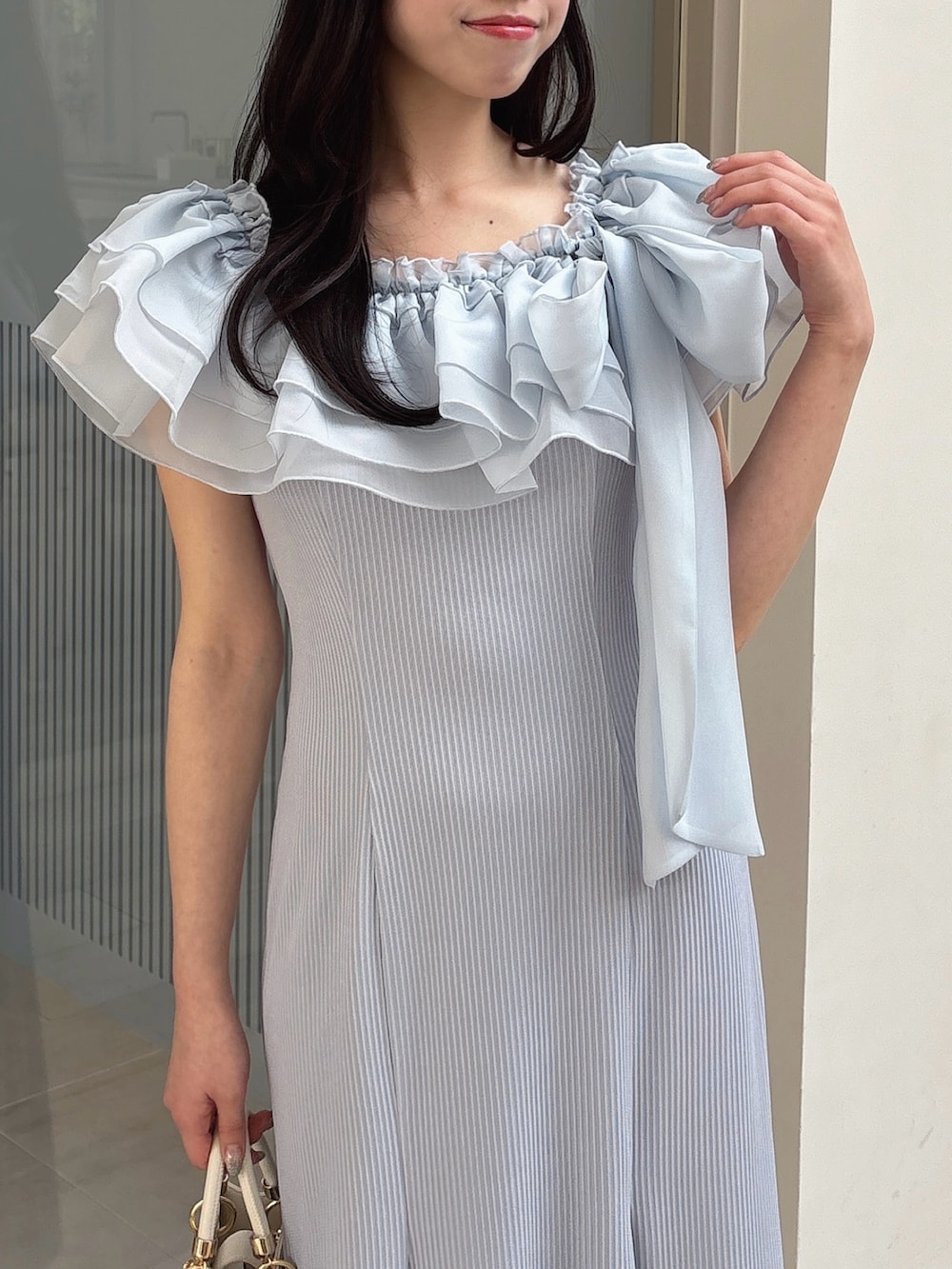 ブルー系のワンピース、ホワイト系のパンプス、ホワイト系のハンドバッグを着用したレディースの春コーディネートの7枚目の写真
