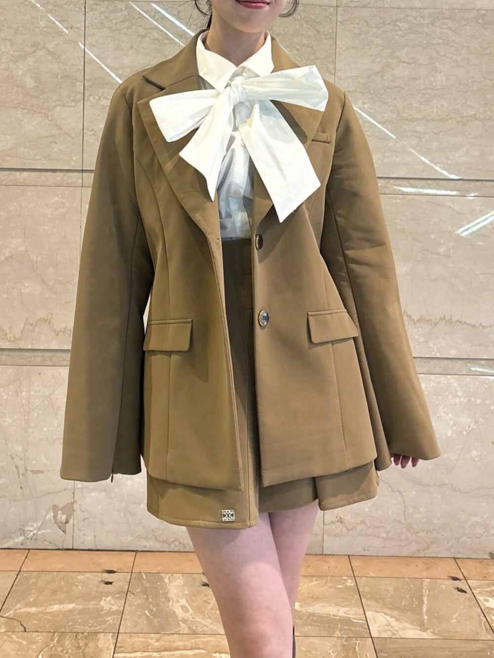 ブラウン系のローファー、ホワイト系のシャツ/ブラウス、ベージュ系のテーラードジャケットを着用したレディースの冬コーディネートの7枚目の写真