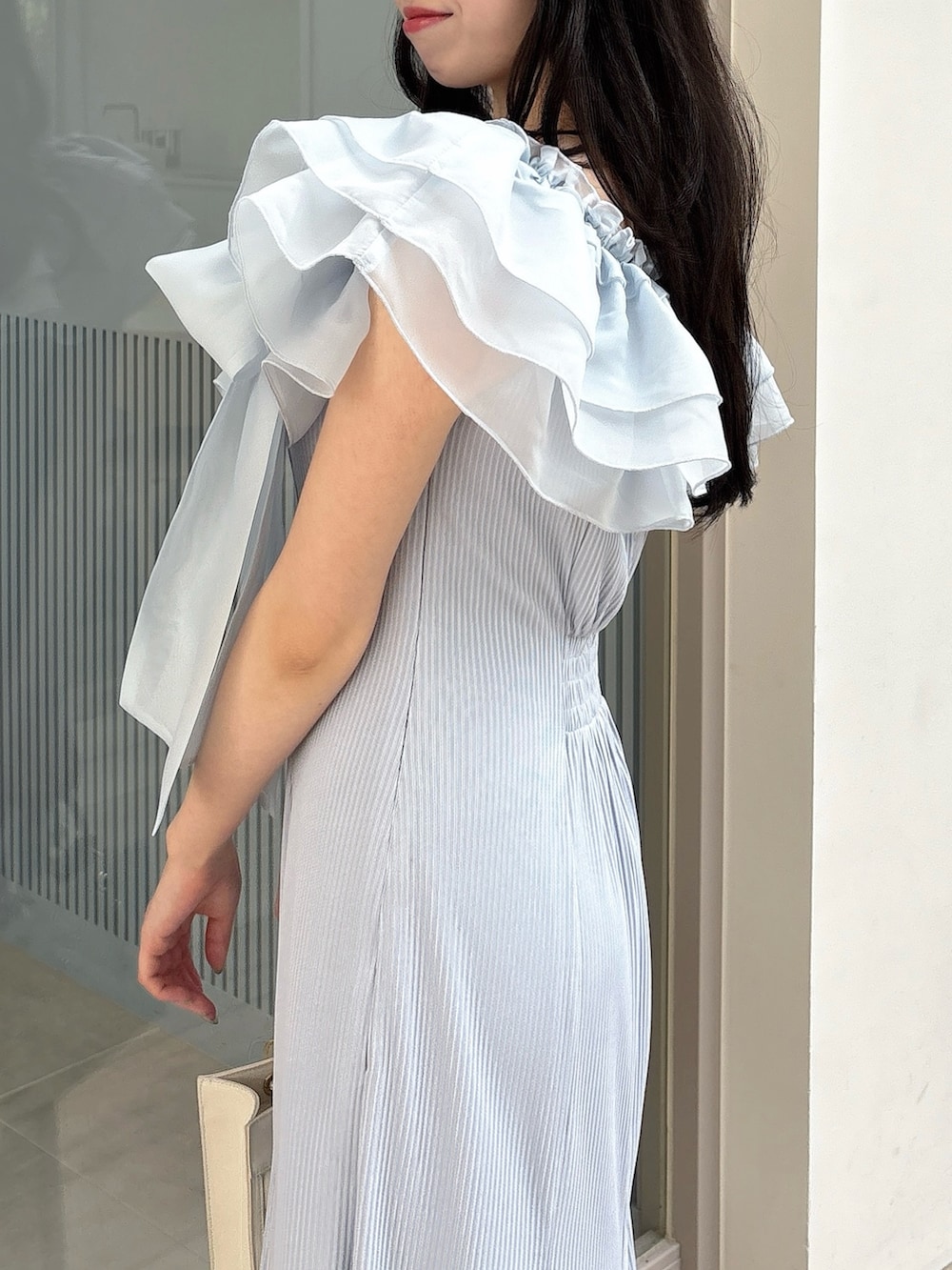 ブルー系のワンピース、ホワイト系のパンプス、ホワイト系のハンドバッグを着用したレディースの春コーディネートの8枚目の写真