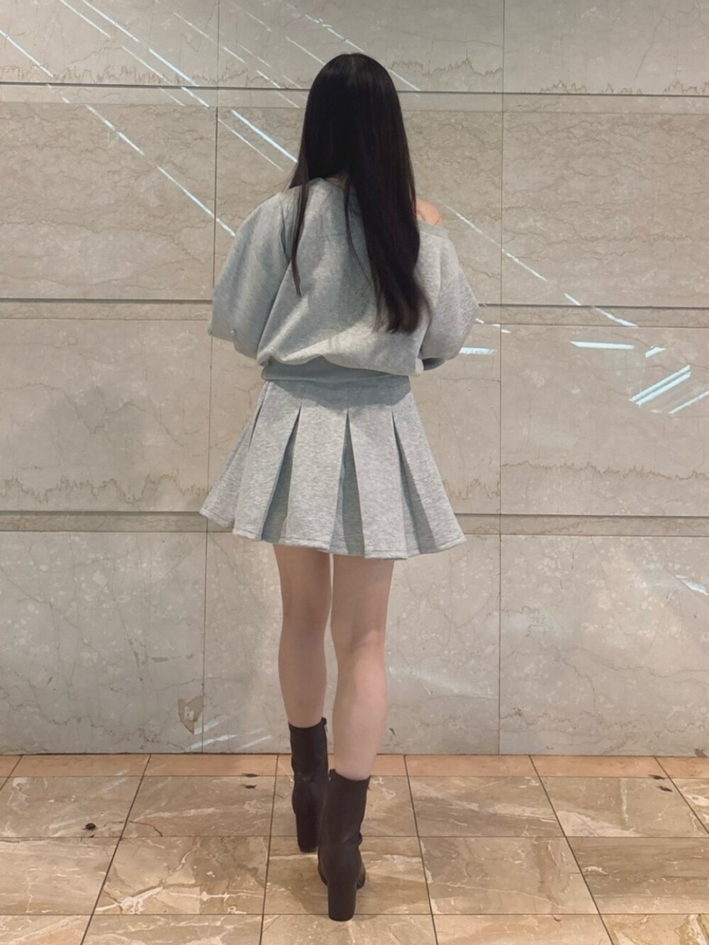 ブラウン系のブーツ、グレー系のスウェット、グレー系のスカートを着用したレディースの秋コーディネートの3枚目の写真