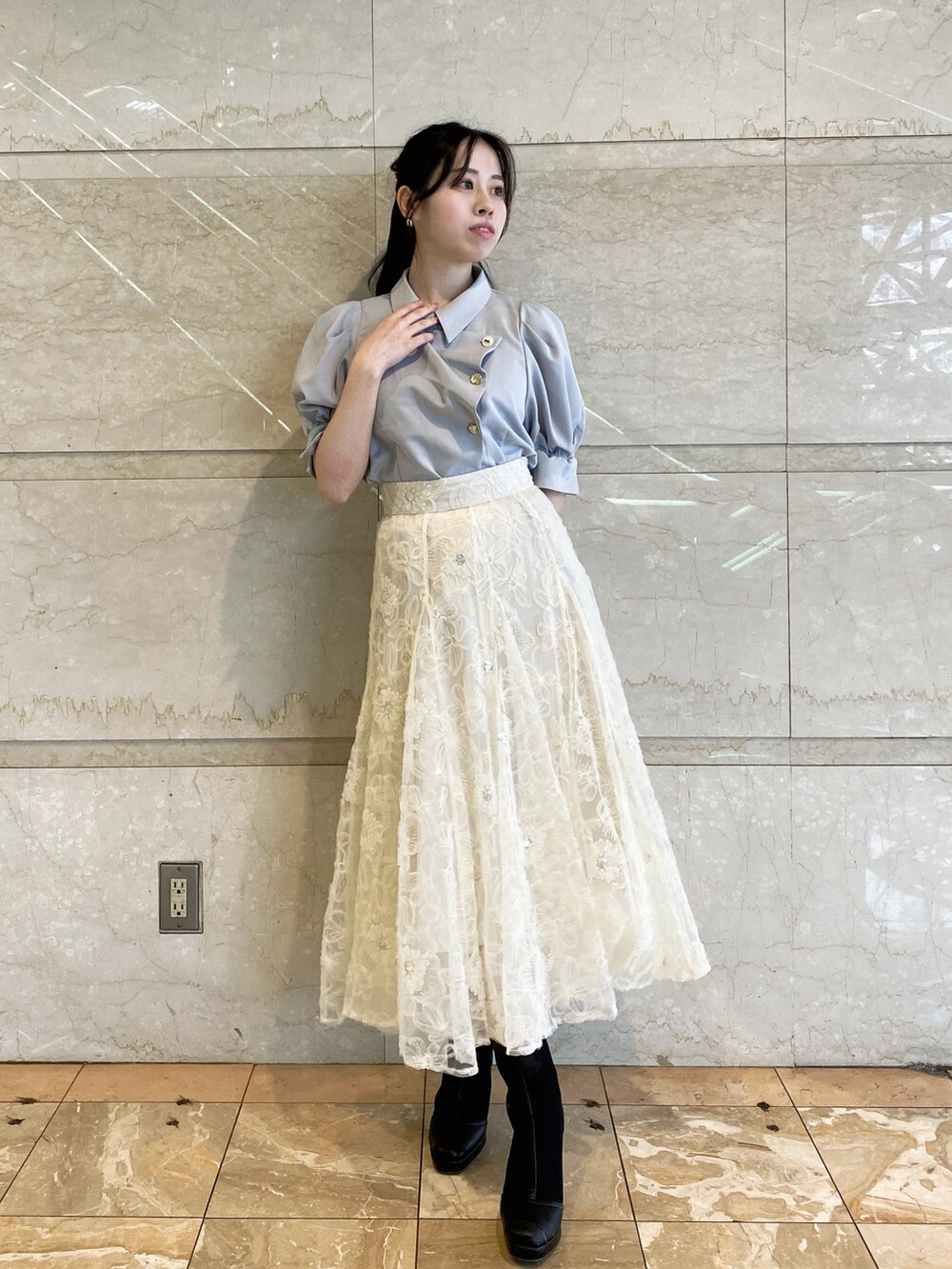 ホワイト系のスカート、グレー系のシャツ/ブラウスを着用したレディースの春コーディネートの2枚目の写真