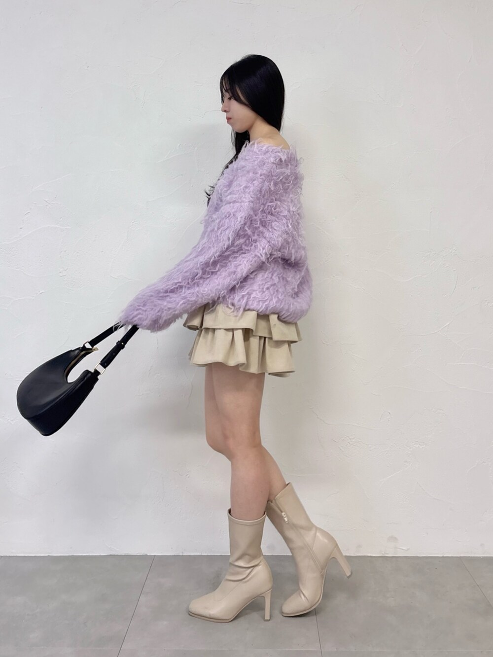 パープル系のニット/セーター、ホワイト系のスカート、ホワイト系のブーツを着用したレディースの秋コーディネートの2枚目の写真