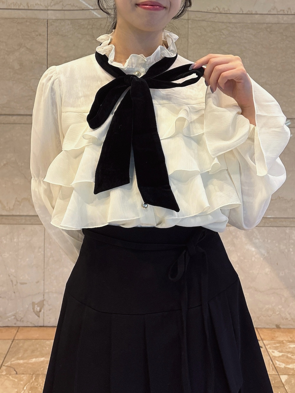 ホワイト系のシャツ/ブラウス、ブラック系のスカート、ブラック系のブーツを着用したレディースの秋コーディネートの4枚目の写真
