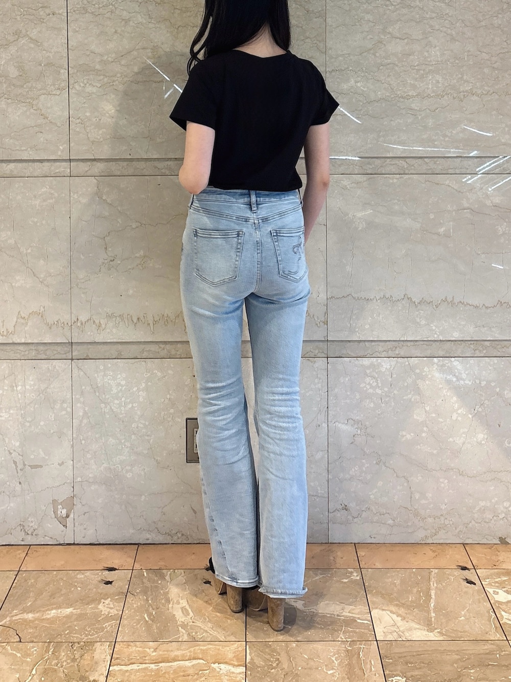 ブラック系のTシャツ/カットソー、ブルー系のデニムパンツ、ブラック系のサンダルを着用したレディースの夏コーディネートの4枚目の写真