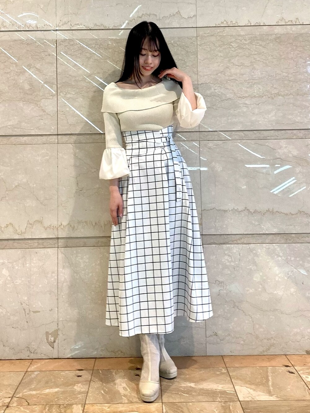 ブラック系のスカート、グレー系のニット/セーターを着用したレディースの冬コーディネートの2枚目の写真