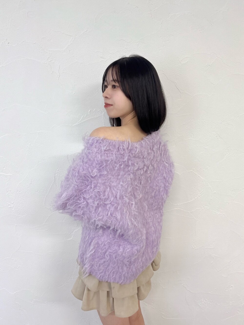 パープル系のニット/セーター、ホワイト系のスカート、ホワイト系のブーツを着用したレディースの秋コーディネートの6枚目の写真