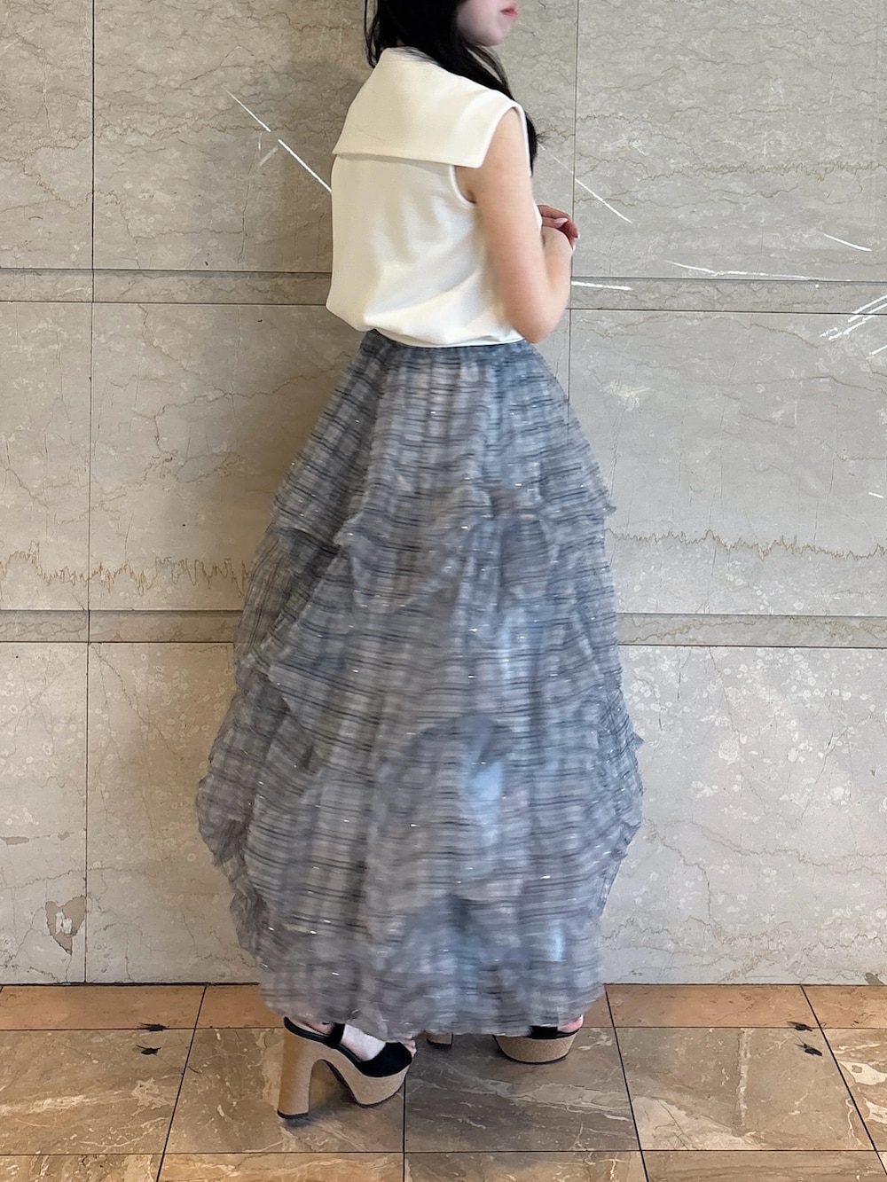 ホワイト系のTシャツ/カットソー、ブルー系のスカート、ブラック系のサンダルを着用したレディースの夏コーディネートの2枚目の写真