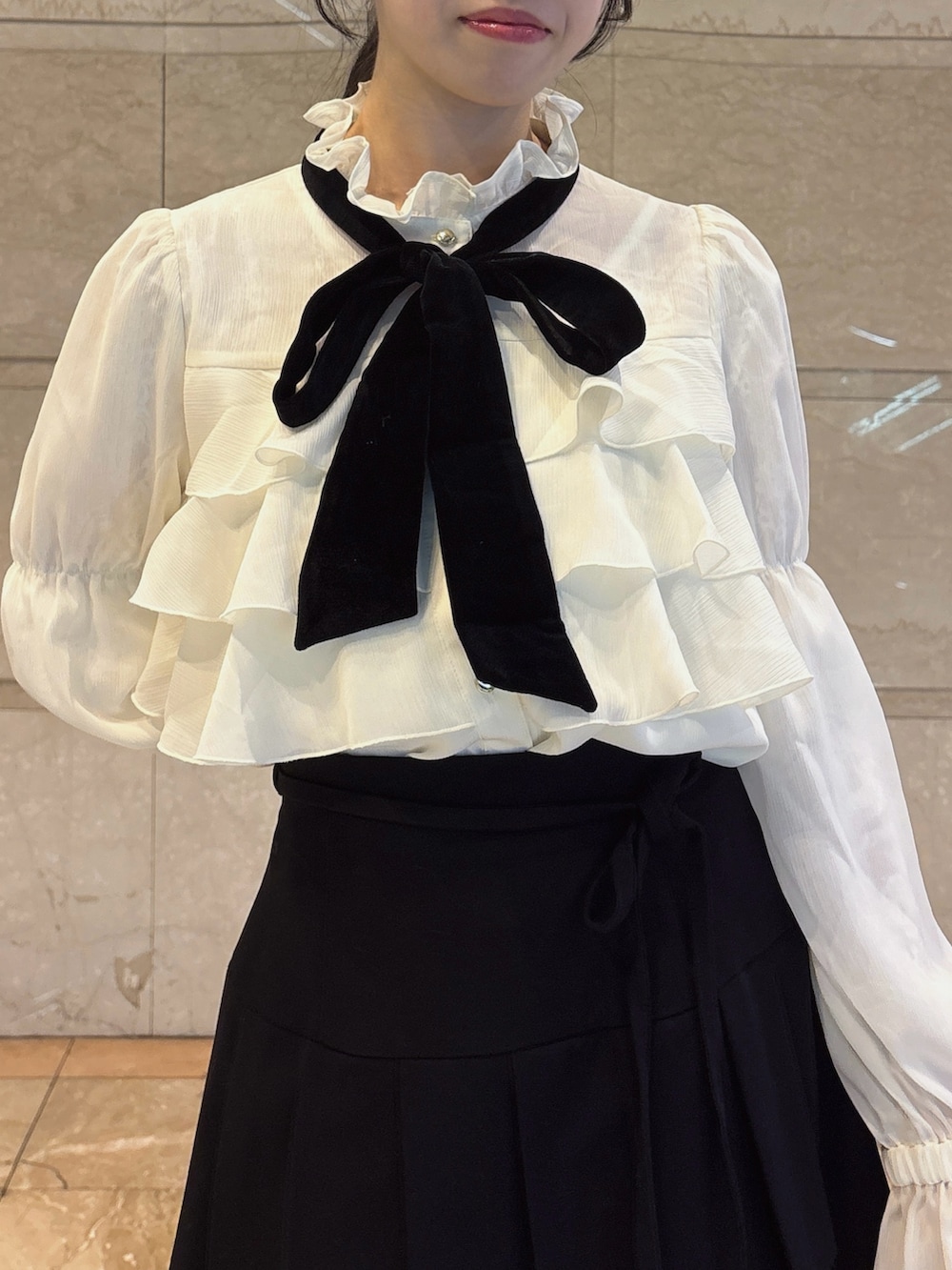 ホワイト系のシャツ/ブラウス、ブラック系のスカート、ブラック系のブーツを着用したレディースの秋コーディネートの5枚目の写真