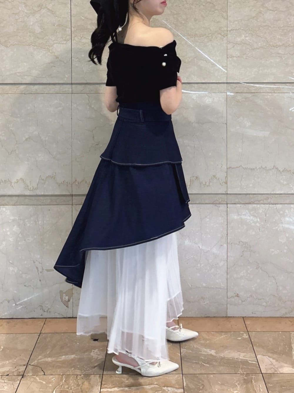 ホワイト系のパンプス、ブルー系のスカート、ブラック系のニット/セーターを着用したレディースの春コーディネートの3枚目の写真