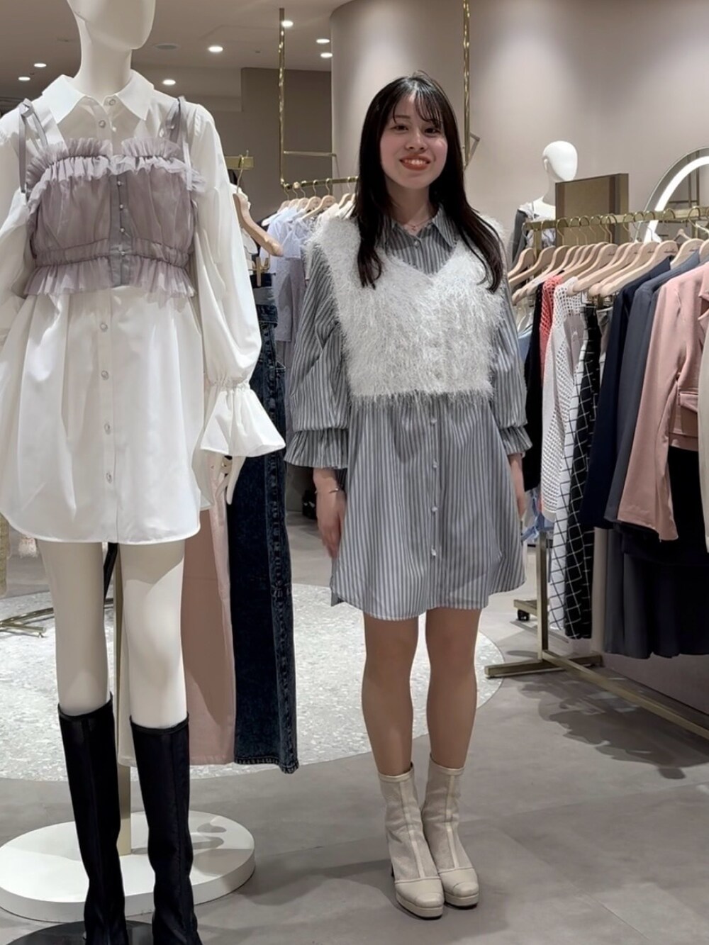 ブルー系のワンピース、ホワイト系のニット/セーターを着用したレディースの春コーディネートの2枚目の写真