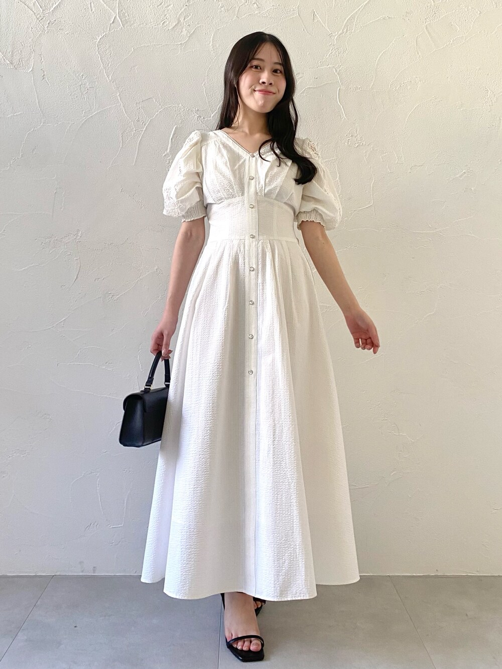 ホワイト系のワンピースを着用したレディースの夏コーディネートの2枚目の写真