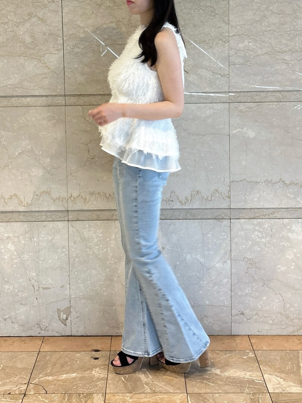 ブラック系のサンダル、ブルー系のデニムパンツ、ホワイト系のタンクトップを着用したレディースの夏コーディネートの4枚目の写真