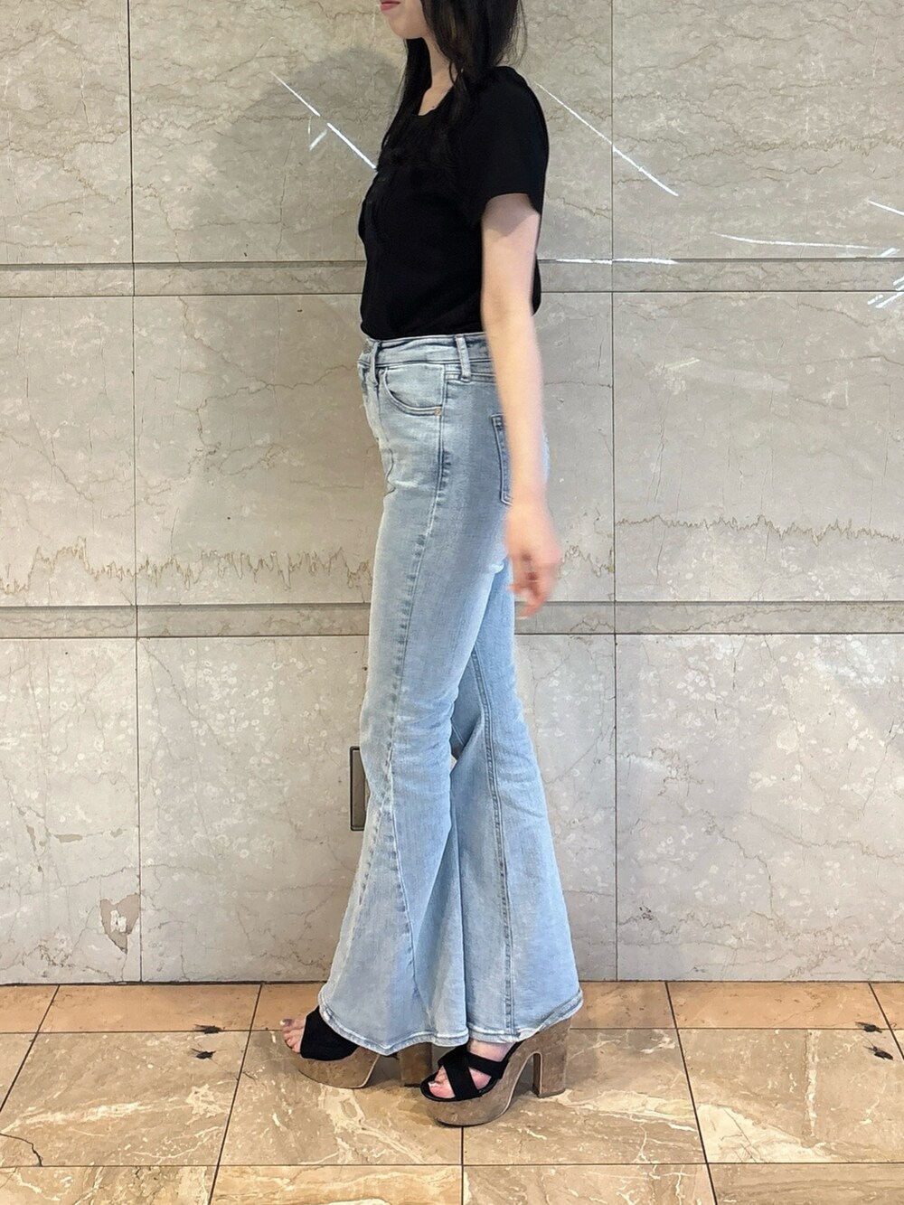 ブラック系のTシャツ/カットソー、ブルー系のデニムパンツ、ブラック系のサンダルを着用したレディースの夏コーディネートの3枚目の写真