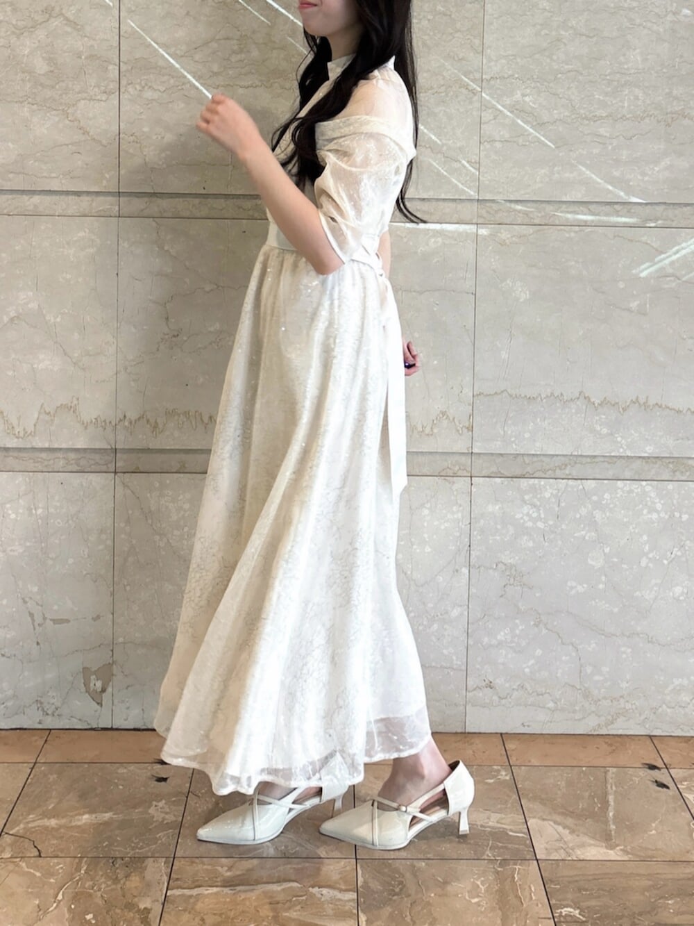 ホワイト系のパンプス、ホワイト系のドレスを着用したレディースの冬コーディネートの4枚目の写真