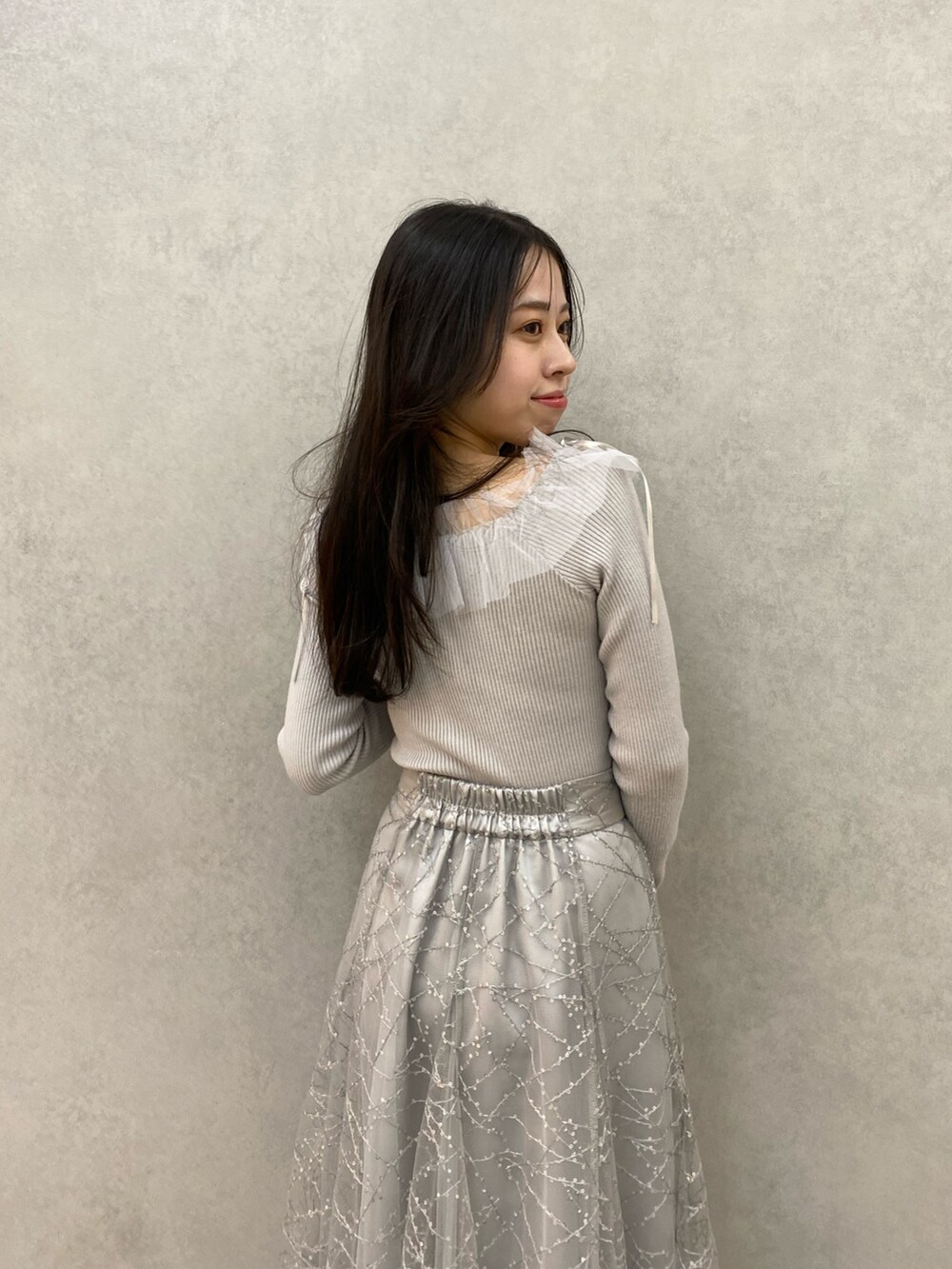 グレー系のニット/セーター、グレー系のスカートを着用したレディースの秋コーディネートの7枚目の写真