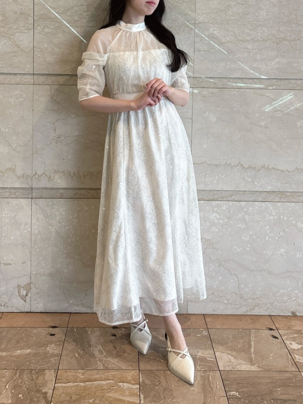 ホワイト系のパンプス、ホワイト系のドレスを着用したレディースの冬コーディネートの6枚目の写真