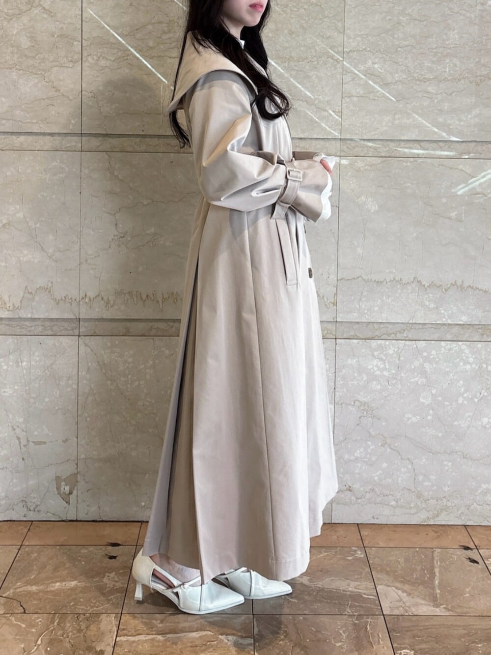 ホワイト系のパンプス、ベージュ系のトレンチコートを着用したレディースの冬コーディネートの3枚目の写真