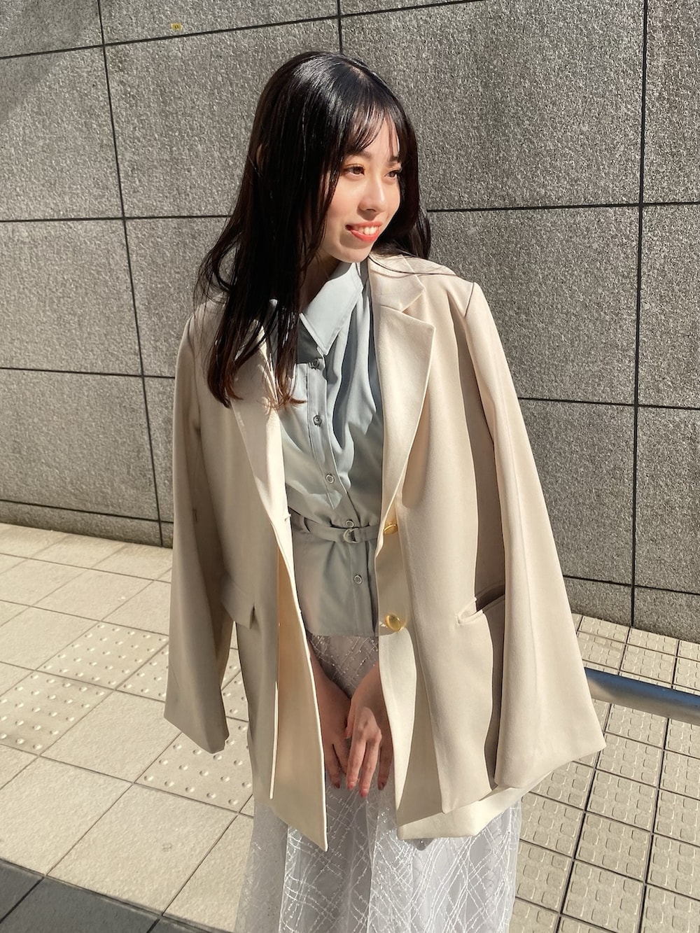 ブルー系のワンピース、ホワイト系のテーラードジャケットを着用したレディースの冬コーディネートの5枚目の写真