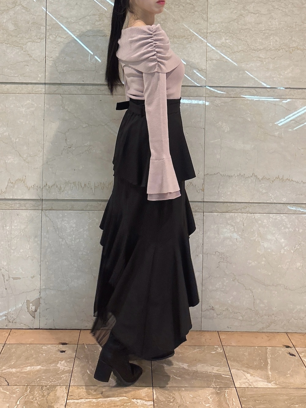 ブラック系のスカート、ピンク系のニット/セーター、ブラック系のブーツを着用したレディースの冬コーディネートの5枚目の写真