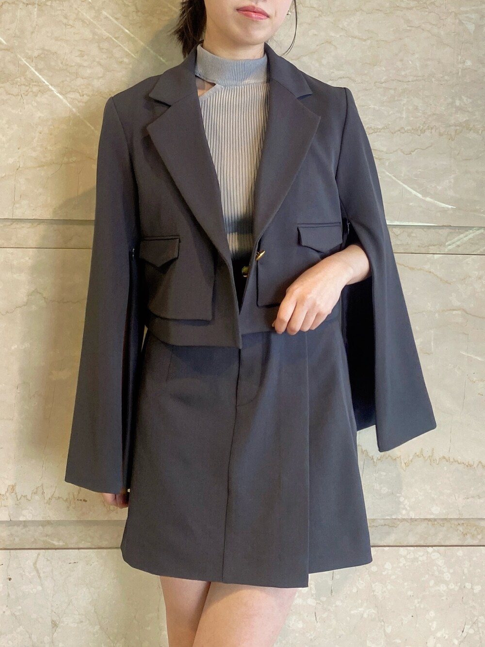 グレー系のテーラードジャケット、グレー系のスカート、グレー系のニット/セーターを着用したレディースの春コーディネートの5枚目の写真