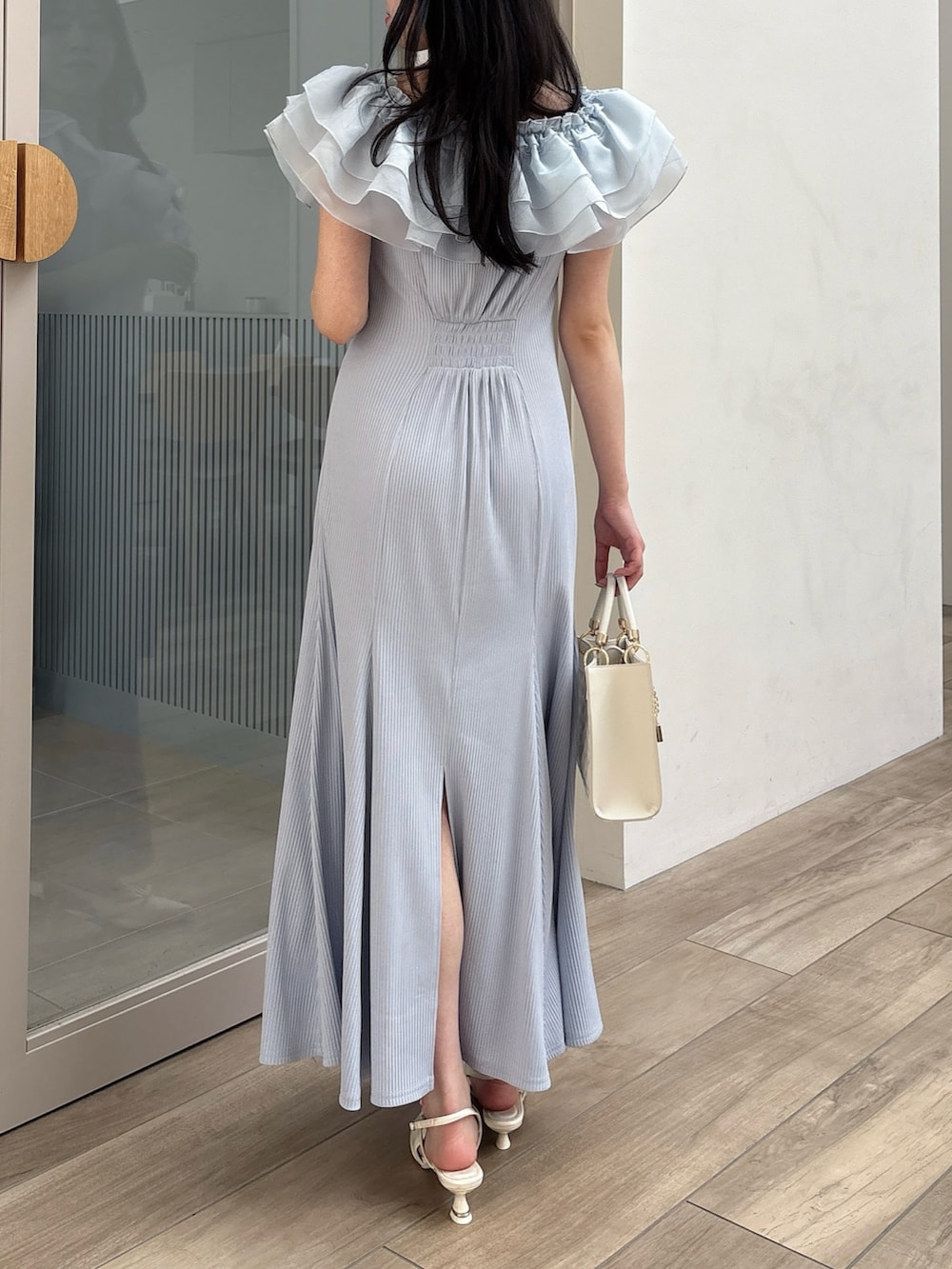 ブルー系のワンピース、ホワイト系のパンプス、ホワイト系のハンドバッグを着用したレディースの春コーディネートの4枚目の写真