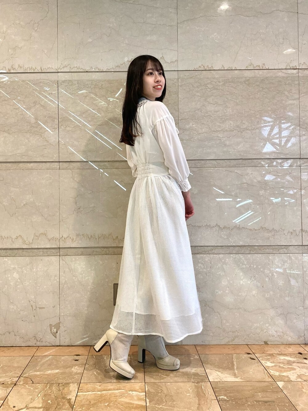 ベージュ系のワンピースを着用したレディースの冬コーディネートの3枚目の写真