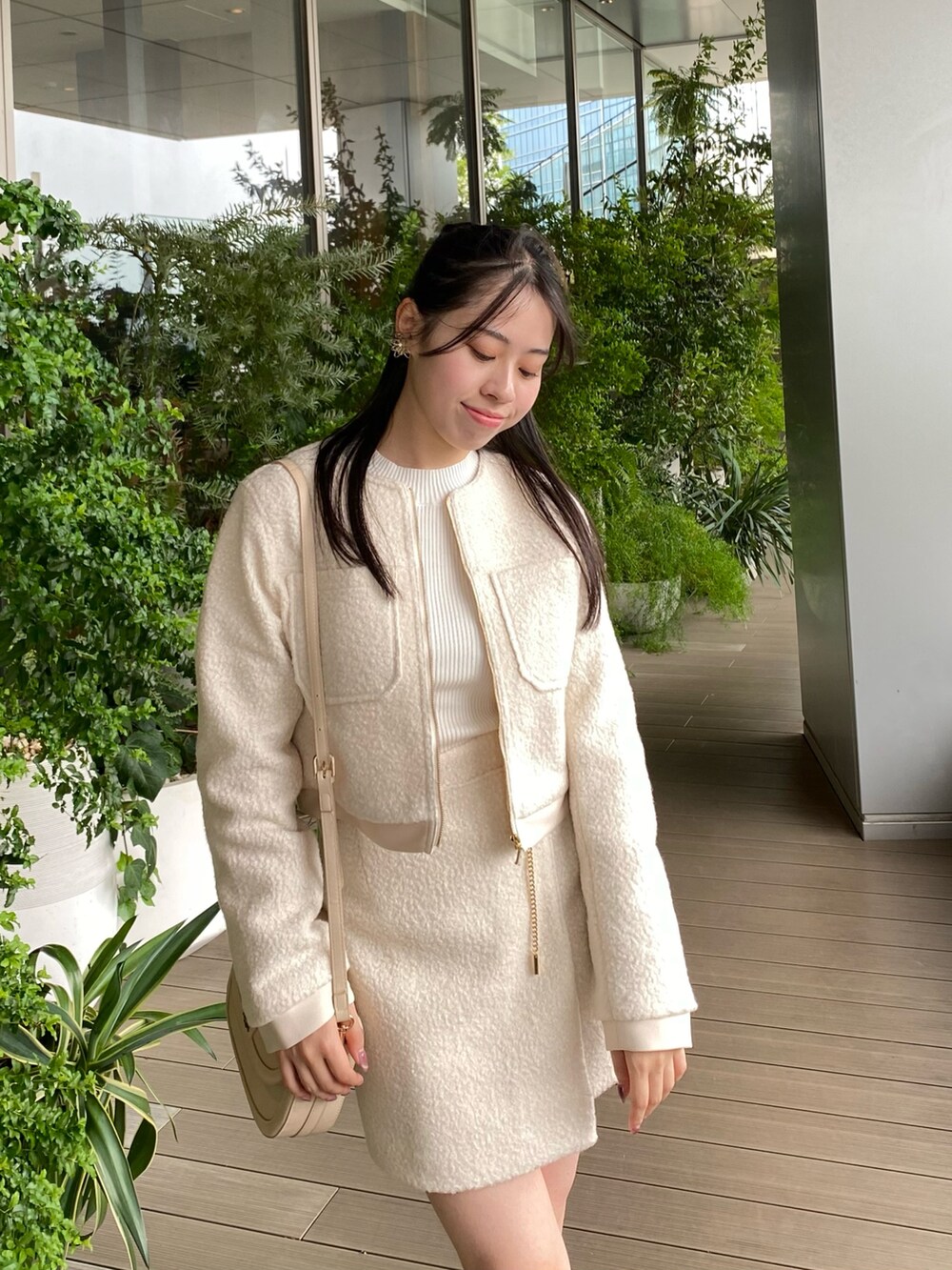 ホワイト系のノーカラージャケット、ホワイト系のスカートを着用したレディースの秋コーディネートの5枚目の写真