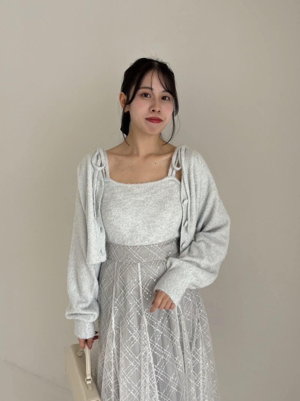 ホワイト系のパンプス、グレー系のカーディガン/ボレロ、グレー系のニット/セーターを着用したレディースの冬コーディネートの6枚目の写真