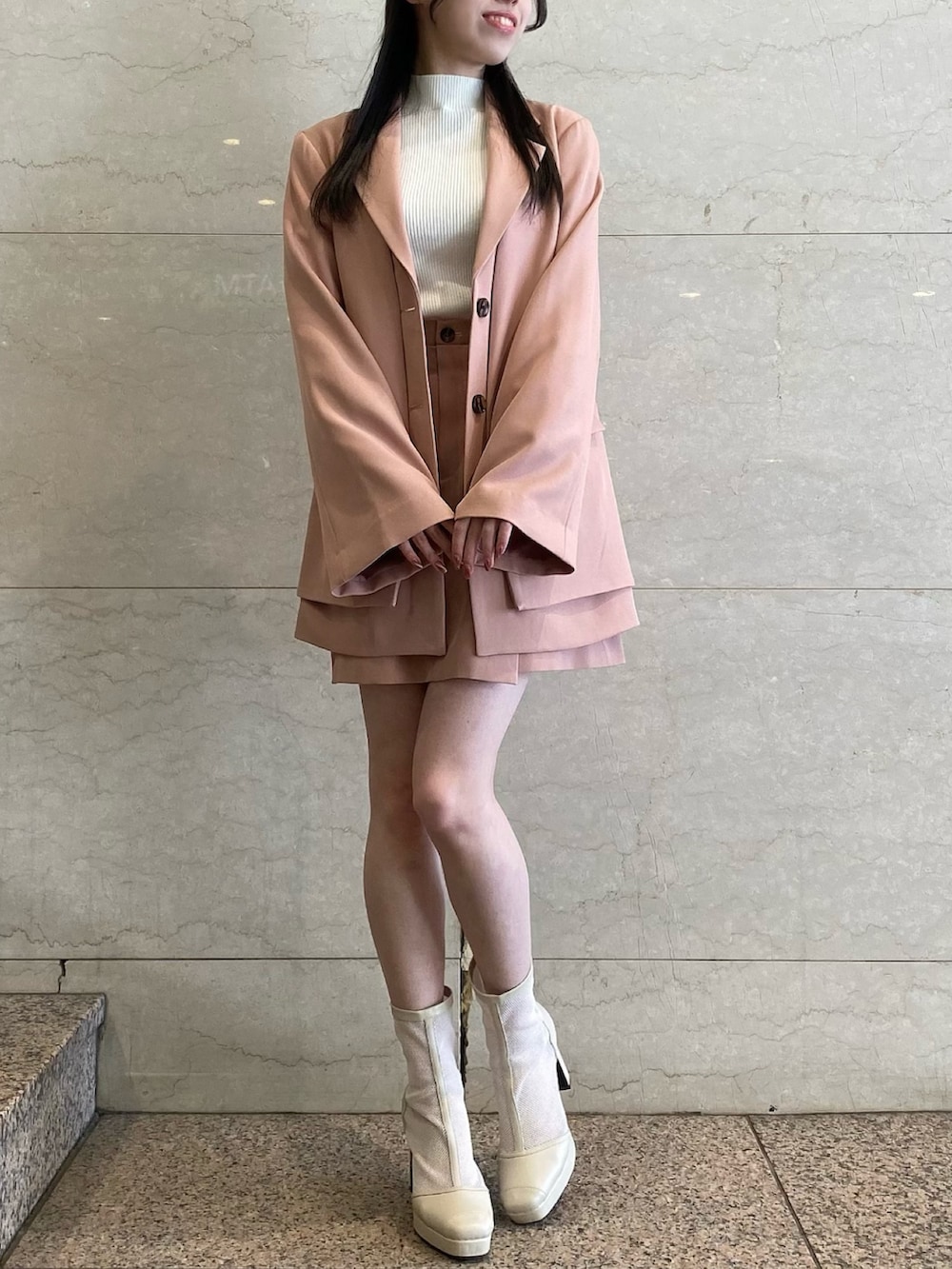 ピンク系のテーラードジャケット、ピンク系のテーラードジャケット、ピンク系のスカートを着用したレディースの冬コーディネートの2枚目の写真