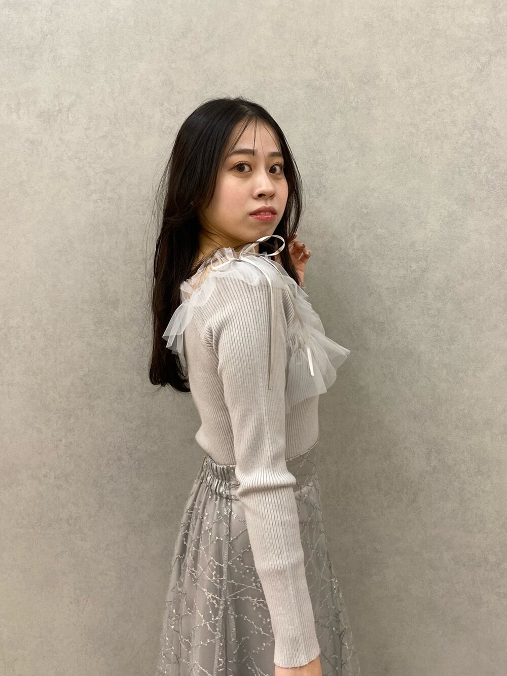 グレー系のニット/セーター、グレー系のスカートを着用したレディースの秋コーディネートの5枚目の写真