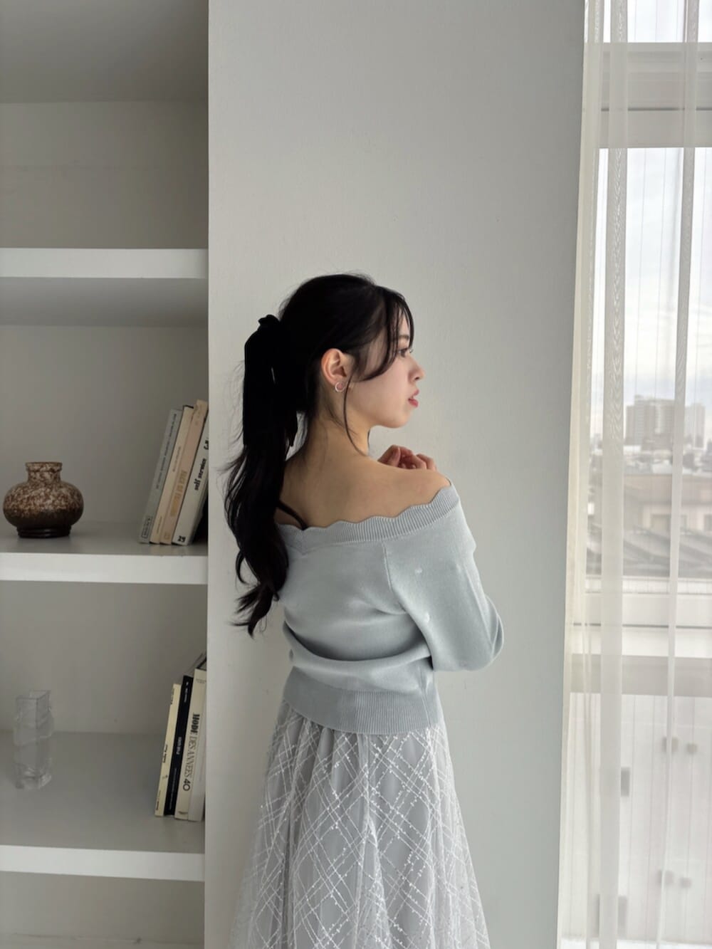 ホワイト系のパンプス、グリーン系のニット/セーター、グレー系のスカートを着用したレディースの冬コーディネートの7枚目の写真