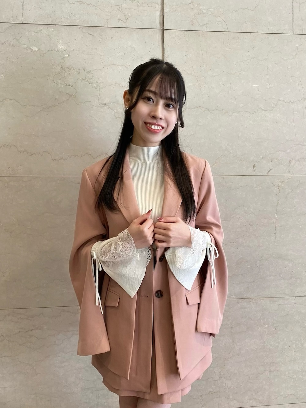 ピンク系のテーラードジャケット、ピンク系のテーラードジャケット、ピンク系のスカートを着用したレディースの冬コーディネートの4枚目の写真