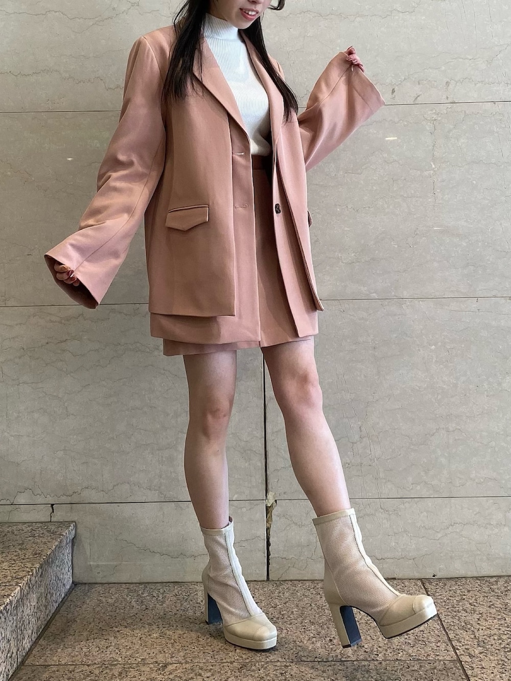 ピンク系のテーラードジャケット、ピンク系のテーラードジャケット、ピンク系のスカートを着用したレディースの冬コーディネートの6枚目の写真