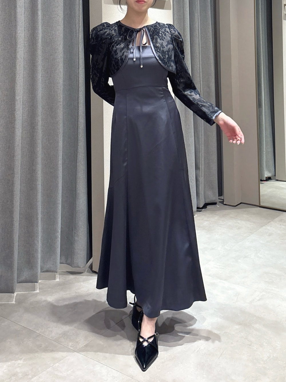 ブラック系のドレス、ブラック系のパンプスを着用したレディースの冬コーディネートの2枚目の写真