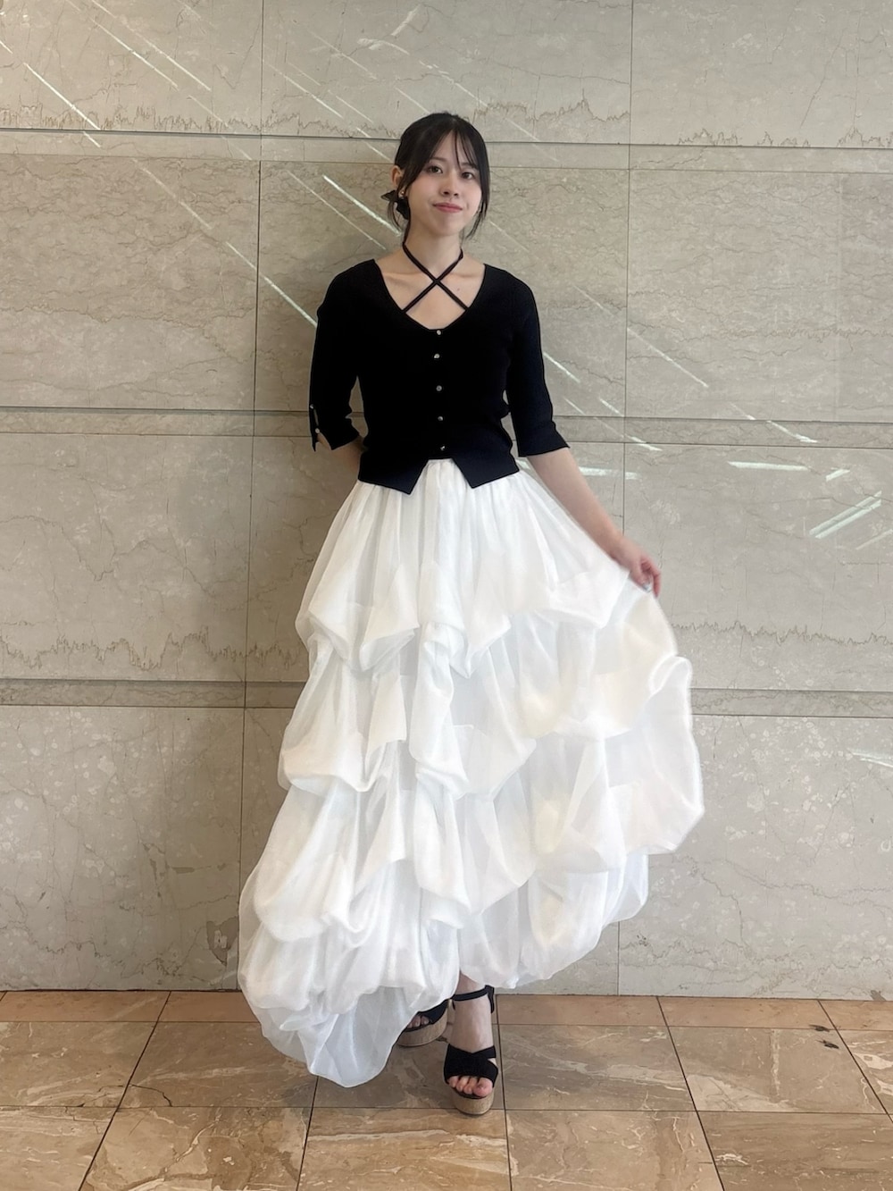 ブラック系のニット/セーター、ホワイト系のスカートを着用したレディースの夏コーディネートの3枚目の写真