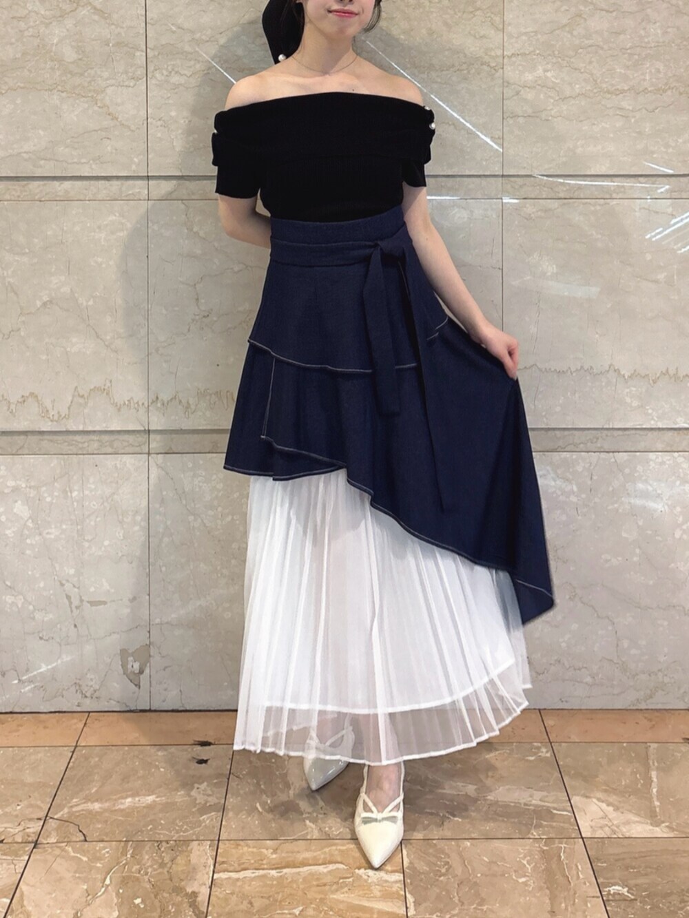 ホワイト系のパンプス、ブルー系のスカート、ブラック系のニット/セーターを着用したレディースの春コーディネートの5枚目の写真