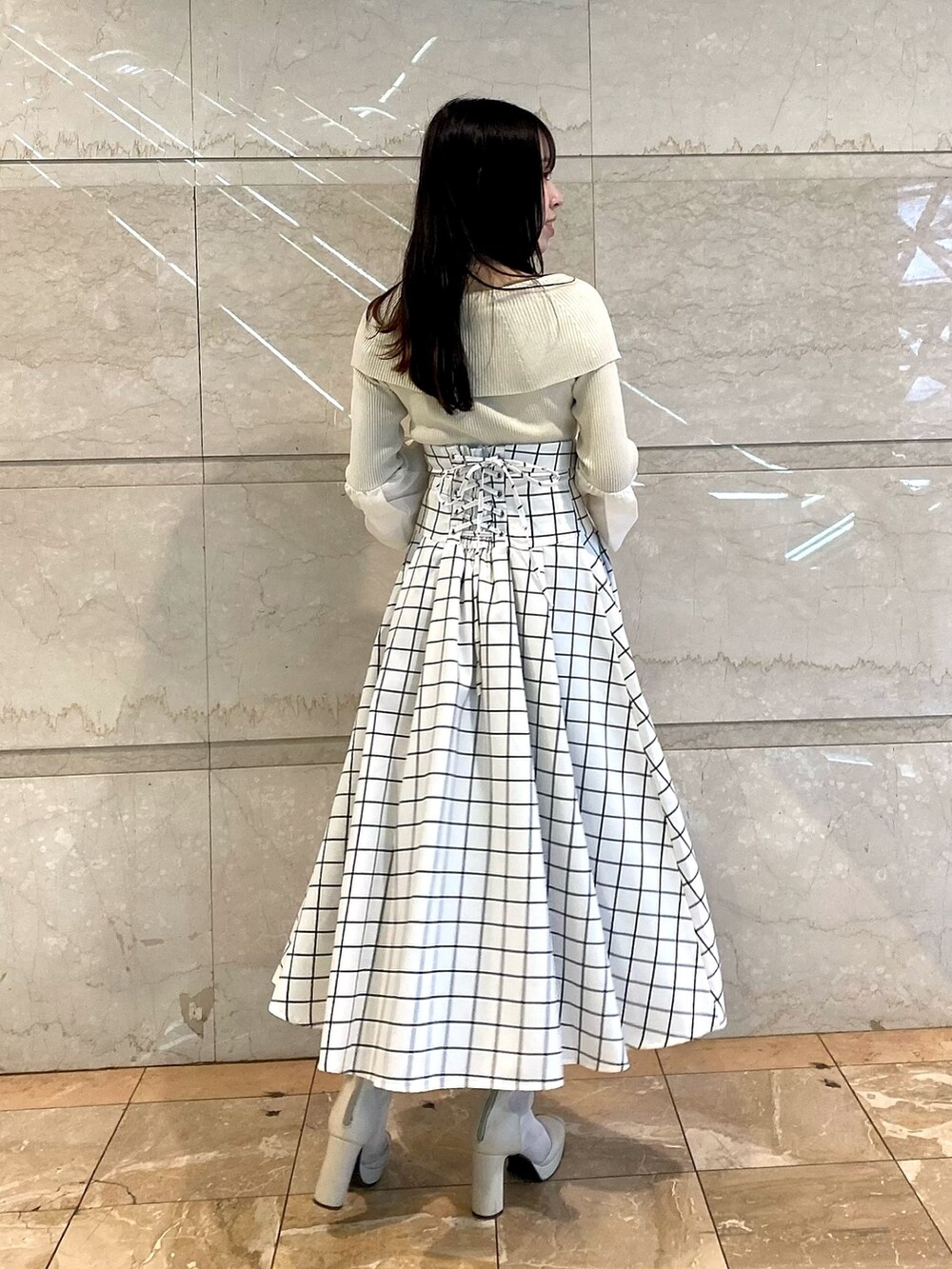 ブラック系のスカート、グレー系のニット/セーターを着用したレディースの冬コーディネートの4枚目の写真