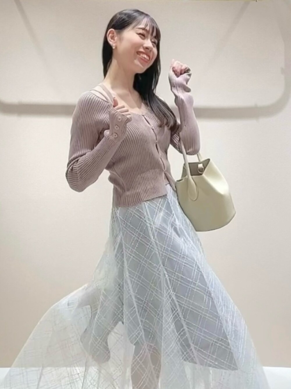 ピンク系のニット/セーター、グレー系のスカートを着用したレディースの冬コーディネートの4枚目の写真