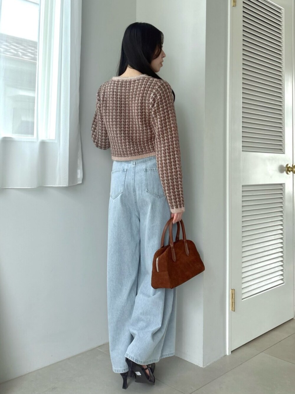 ブルー系のデニムパンツ、ブラウン系のカーディガン/ボレロを着用したレディースの秋コーディネートの4枚目の写真