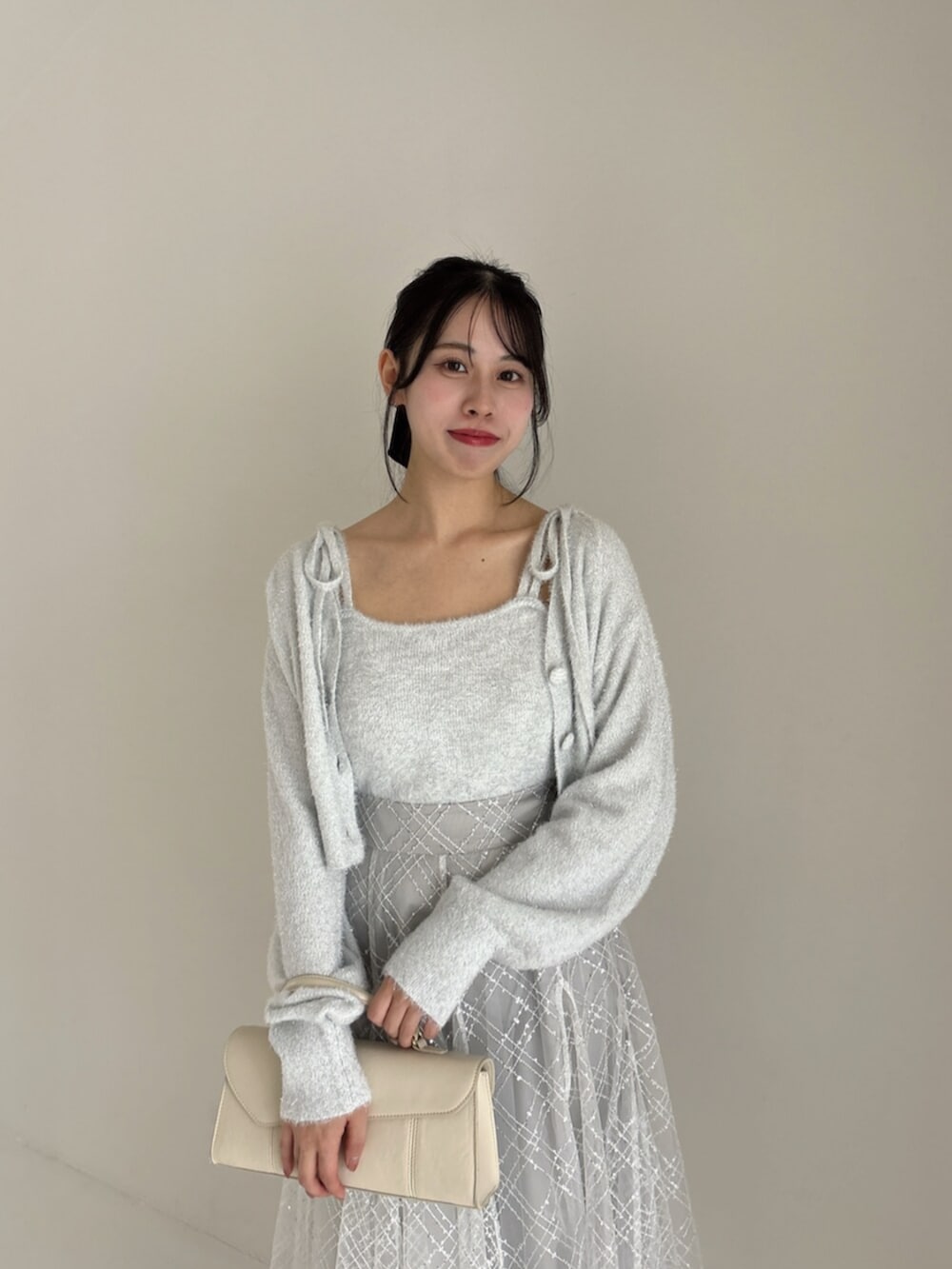 ホワイト系のパンプス、グレー系のカーディガン/ボレロ、グレー系のニット/セーターを着用したレディースの冬コーディネートの5枚目の写真