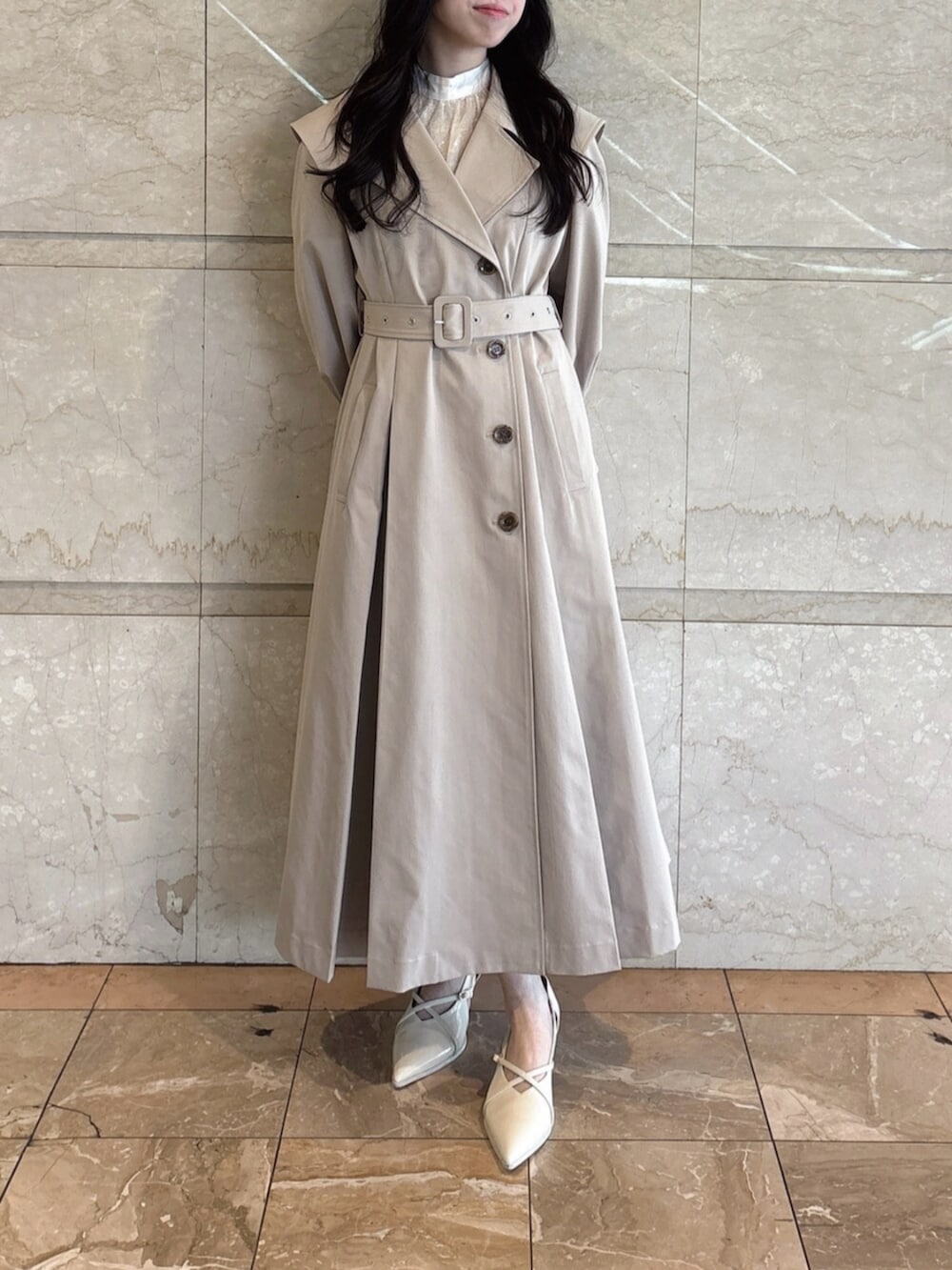 ホワイト系のパンプス、ベージュ系のトレンチコートを着用したレディースの冬コーディネートの5枚目の写真