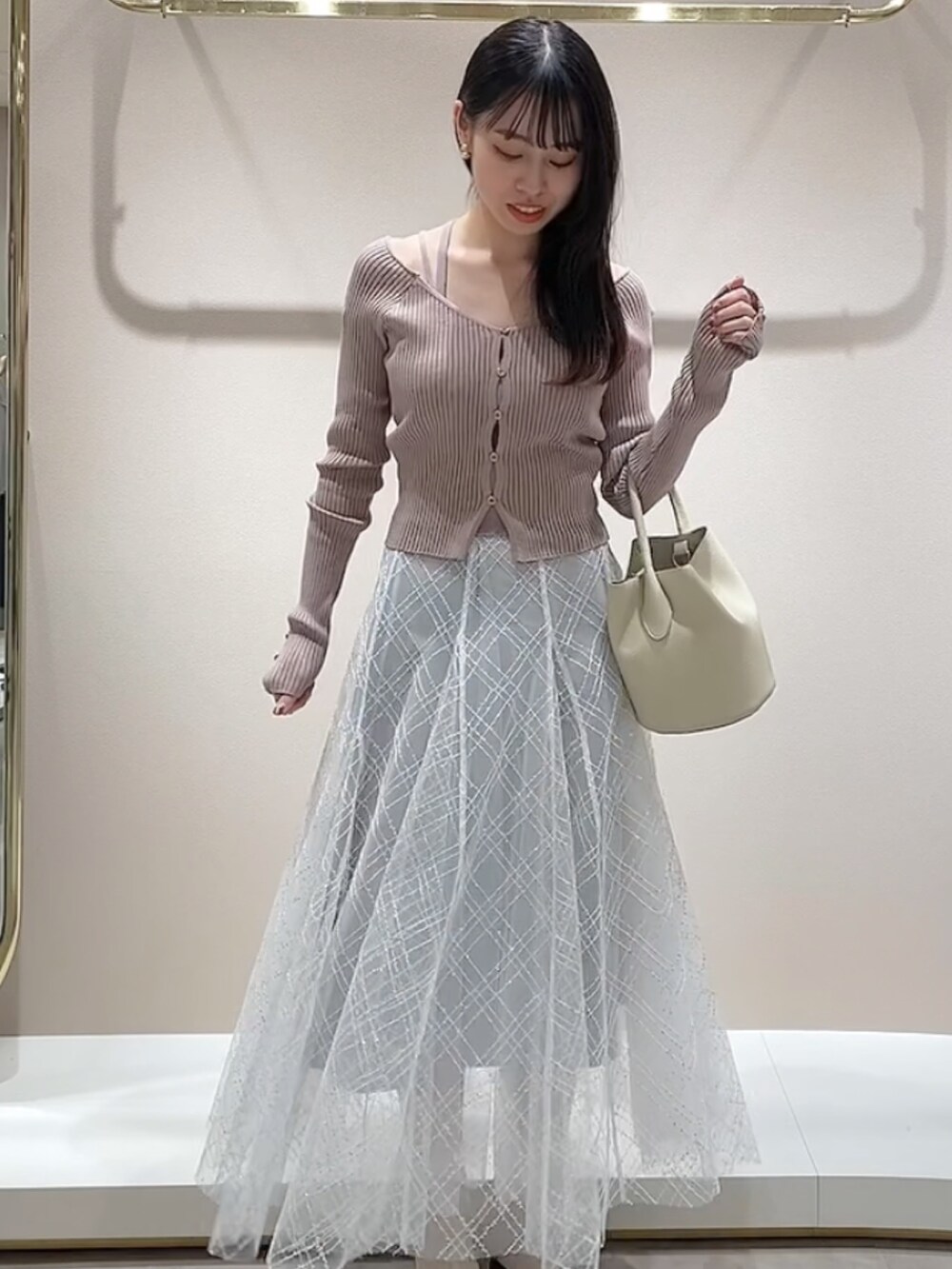 ピンク系のニット/セーター、グレー系のスカートを着用したレディースの冬コーディネートの2枚目の写真