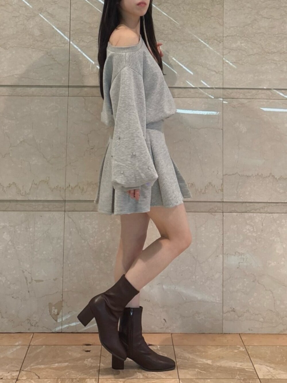 ブラウン系のブーツ、グレー系のスウェット、グレー系のスカートを着用したレディースの秋コーディネートの4枚目の写真