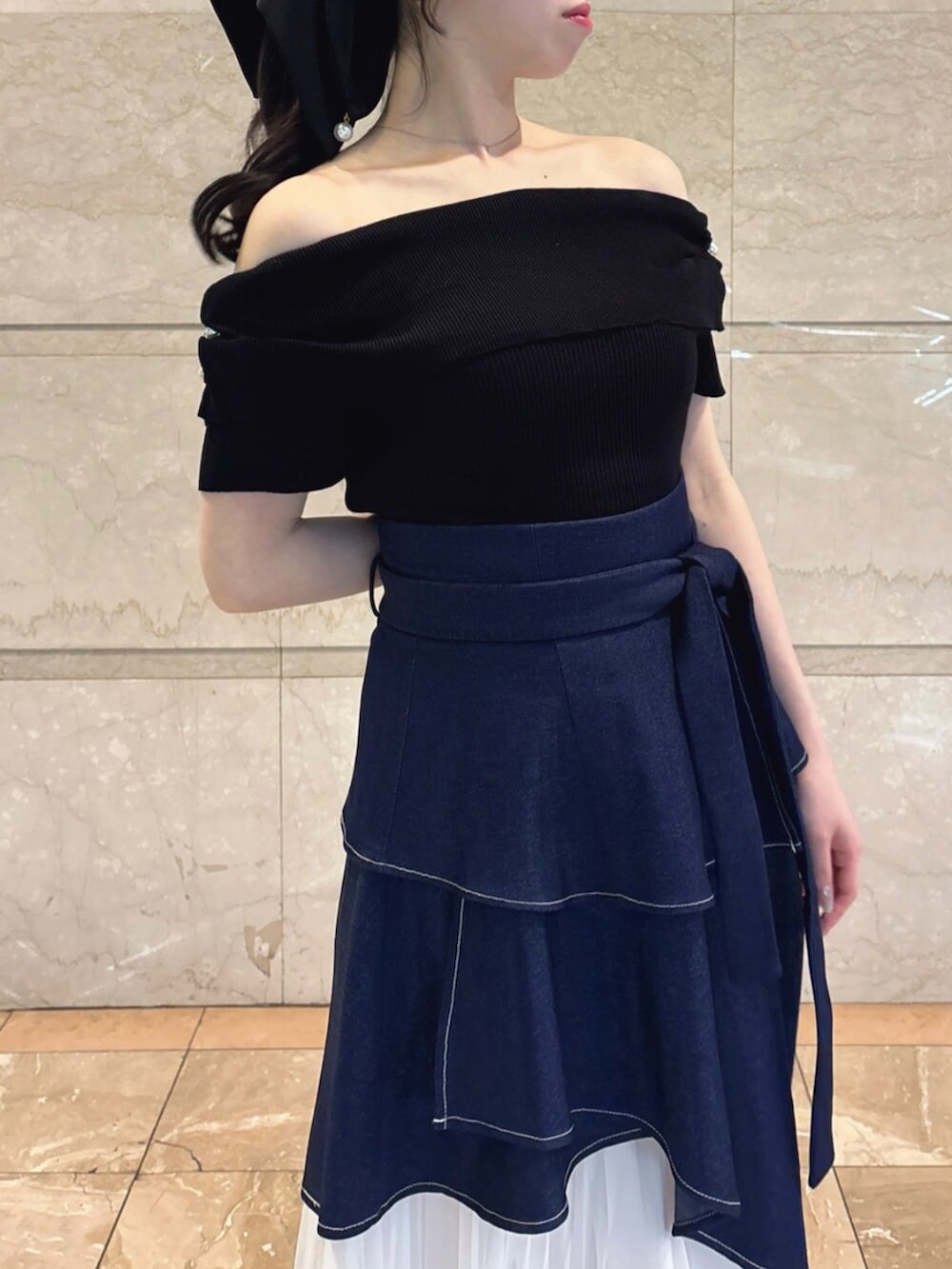 ホワイト系のパンプス、ブルー系のスカート、ブラック系のニット/セーターを着用したレディースの春コーディネートの8枚目の写真
