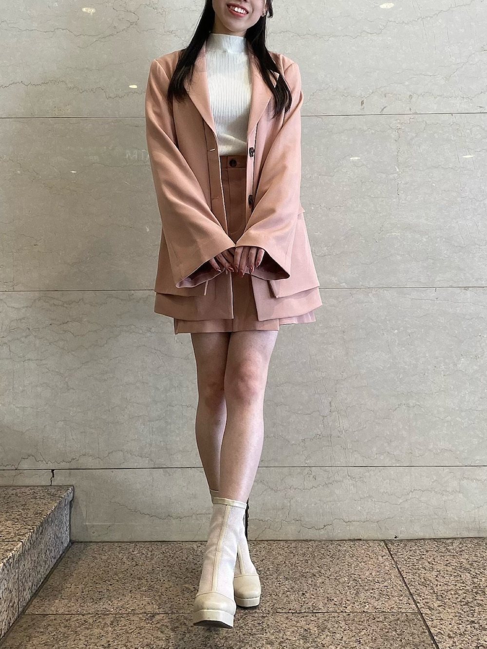 ピンク系のテーラードジャケット、ピンク系のテーラードジャケット、ピンク系のスカートを着用したレディースの冬コーディネートの5枚目の写真