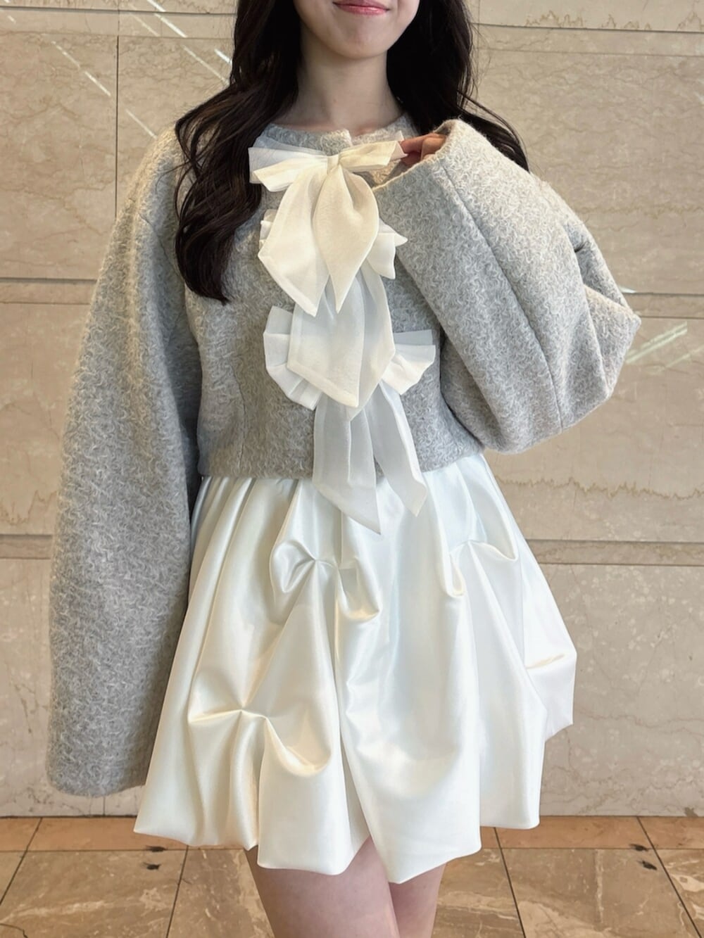 ブラウン系のローファー、グレー系のブルゾン、ホワイト系のスカートを着用したレディースの冬コーディネートの8枚目の写真